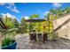 Outdoor deck featuring a glass table and chairs, an umbrella and beautiful landscaping with mature trees at 6901 E 12Th Ave, Denver, CO 80220
