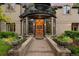 Inviting front entrance with custom double doors, elegant planters, and a welcoming stone pathway leading to the home at 6901 E 12Th Ave, Denver, CO 80220