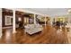 Spacious living room with hardwood floors, decorative columns, an elegant staircase, and seamlessly connected living spaces at 6901 E 12Th Ave, Denver, CO 80220