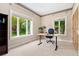Bright home office featuring carpeted floors, two windows with outside views, and a classic wooden door at 6901 E 12Th Ave, Denver, CO 80220