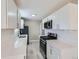 Contemporary kitchen featuring white cabinets, stainless steel appliances, and sleek countertops at 382 S Decatur St, Denver, CO 80219