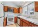 Functional kitchen featuring a white oven, wood cabinets, and a sink with a bright window above at 262 S Nome St, Aurora, CO 80012
