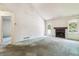 Bright living room with a cozy fireplace, a door for access, and neutral walls and floors at 262 S Nome St, Aurora, CO 80012
