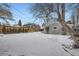 Snowy backyard with detached garage and trees at 2354 S Ogden St, Denver, CO 80210