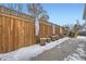 Wooden fence, patio, and snow-covered ground in backyard at 2354 S Ogden St, Denver, CO 80210