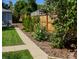 Side yard with walkway, wood fence, and lush landscaping at 2354 S Ogden St, Denver, CO 80210