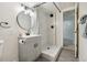 Elegant bathroom featuring a gray vanity, round mirror, tiled shower, and neutral accents at 6193 Holland St, Arvada, CO 80004