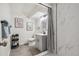 Modern bathroom featuring gray vanity, tile flooring, tiled shower with curtain and decorative wall art at 6193 Holland St, Arvada, CO 80004