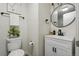Stylish bathroom with white vanity, updated fixtures, round mirror, and neutral decor at 6193 Holland St, Arvada, CO 80004