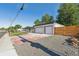 Exterior view of a two-car garage with a wide driveway and a newly fenced yard at 6193 Holland St, Arvada, CO 80004