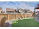 Well manicured backyard with privacy fence, artificial lawn, and a rock garden adjacent to other suburban homes at 1188 Sugarloaf Ln, Erie, CO 80516