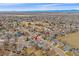 Expansive aerial view of the neighborhood with beautiful mountain views from a distance and a red arrow pointing to the home at 13472 Monroe St, Thornton, CO 80241