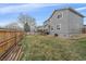 Large backyard with lawn, wooden fence, home exterior, and mature trees offers privacy at 13472 Monroe St, Thornton, CO 80241