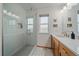 Modern bathroom featuring glass shower doors, a tiled shower with a niche, and a wood vanity at 13472 Monroe St, Thornton, CO 80241