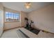 Bright bedroom featuring a ceiling fan, a large window, and a designated workout area at 13472 Monroe St, Thornton, CO 80241