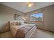 Cozy bedroom with a ceiling fan, a comfortable bed, neutral walls, and a view to the outside at 13472 Monroe St, Thornton, CO 80241