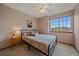 Comfortable bedroom with a ceiling fan, a comfortable bed, neutral walls, and a view to the outside at 13472 Monroe St, Thornton, CO 80241