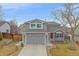 Charming two-story home with a well-manicured lawn, attached two-car garage and a red front door at 13472 Monroe St, Thornton, CO 80241
