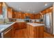 Bright kitchen featuring wood cabinets, stainless steel appliances, a marble backsplash, and center island with marble countertop at 13472 Monroe St, Thornton, CO 80241