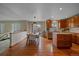 Open-concept kitchen and dining area with hardwood floors, stainless steel appliances, and a center island at 13472 Monroe St, Thornton, CO 80241