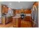 This kitchen features wood cabinetry, stainless steel appliances, a marble backsplash, and center island with marble countertop at 13472 Monroe St, Thornton, CO 80241