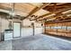Spacious garage with exposed ceiling beams, cabinets, and an adjacent stove at 851 S Umatilla Way, Denver, CO 80223