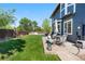 Well-maintained backyard with a concrete patio, outdoor furniture, and lush green grass at 11545 E 119Th Ave, Commerce City, CO 80640