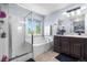 Bathroom with a soaking tub with glass door, large vanity with dual sinks, and a separate shower at 11545 E 119Th Ave, Commerce City, CO 80640