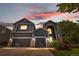 Charming two-story home featuring a well-manicured lawn, two-car garage, and beautiful flowering bushes at 11545 E 119Th Ave, Commerce City, CO 80640