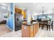 Open kitchen with black stainless appliances, island, wine rack, and view to the living and dining areas at 11545 E 119Th Ave, Commerce City, CO 80640