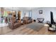 Open-concept living room with wood floors and comfortable leather sofas at 11545 E 119Th Ave, Commerce City, CO 80640