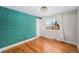 Bedroom with teal bird wallpaper and hardwood floors at 2775 E Dartmouth Ave, Denver, CO 80210