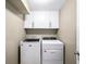 Basement laundry room with washer, dryer, and white cabinets at 2775 E Dartmouth Ave, Denver, CO 80210