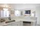 Bright kitchen with white cabinets, quartz countertops, and a breakfast bar at 2245 E 103Rd Pl, Thornton, CO 80229