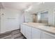 Bright bathroom with double sinks, white cabinets, and decorative lighting above the mirror at 10288 Salida St, Commerce City, CO 80022