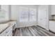 Bright dining area featuring gray wood flooring, white walls, and two windows at 10288 Salida St, Commerce City, CO 80022