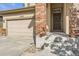 Inviting front entrance featuring a brick pillar, concrete steps and a dark brown front door at 10288 Salida St, Commerce City, CO 80022