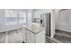 Bright kitchen with granite countertops, stainless steel refrigerator, and gray wood floors at 10288 Salida St, Commerce City, CO 80022