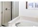 Bathroom featuring a glass-enclosed shower and a large soaking tub with tile surround at 17020 W 64Th Dr, Arvada, CO 80007