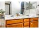 Bathroom featuring a double sink vanity with wood cabinets and a large mirror at 17020 W 64Th Dr, Arvada, CO 80007