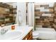 Stylish bathroom featuring a modern vanity, decorative tile accents, and a shower-tub combination at 17020 W 64Th Dr, Arvada, CO 80007