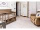 Bright bedroom with wooden crib, beige carpet, and light-colored walls creates a serene atmosphere at 17020 W 64Th Dr, Arvada, CO 80007