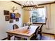 Elegant dining room with a wooden table, chandelier, and large window overlooking the outdoors at 17020 W 64Th Dr, Arvada, CO 80007