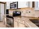Kitchen featuring granite countertops, stainless steel appliances, and tan-tiled backsplash at 17020 W 64Th Dr, Arvada, CO 80007