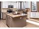 Stylish kitchen with stainless steel appliances, tile backsplash, and a spacious center island at 17020 W 64Th Dr, Arvada, CO 80007