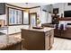 Open concept kitchen and living room with shuttered windows, wood trim, and granite countertops at 17020 W 64Th Dr, Arvada, CO 80007