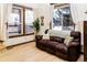 Cozy living room featuring large windows, hardwood floors, and a comfortable couch for relaxation at 17020 W 64Th Dr, Arvada, CO 80007