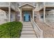 Inviting multi-story condo with brick facade, painted teal front door, and convenient accessible entrance at 1771 W 53Rd Pl # 1, Denver, CO 80221