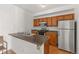 Well-lit kitchen featuring wooden cabinets, stainless steel appliances, and functional island at 1771 W 53Rd Pl # 1, Denver, CO 80221