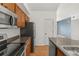 Modern kitchen with wooden cabinets, stainless steel appliances, and open layout into other rooms at 1771 W 53Rd Pl # 1, Denver, CO 80221